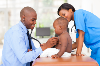 african american pediatric doctor examining baby boy with female nurse